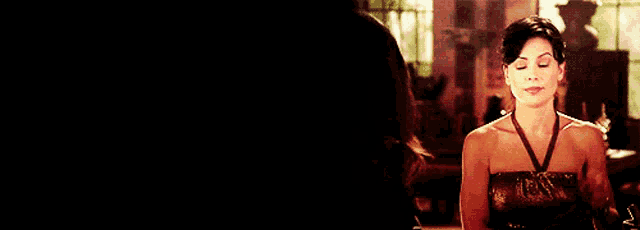 a woman in a strapless dress is looking at herself in the mirror