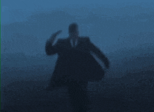a man in a suit and tie is being shot in the head .