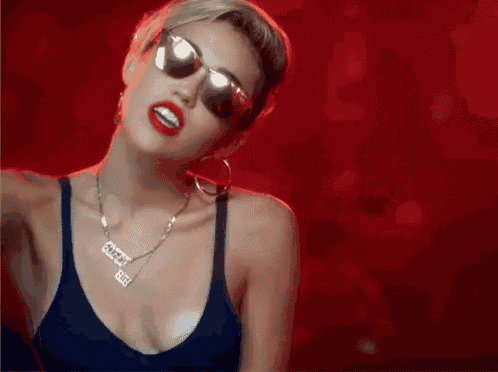 a woman wearing sunglasses and a necklace that says " ugly "