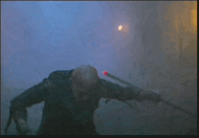 a man with a bandaged arm is holding a sword in his hands .