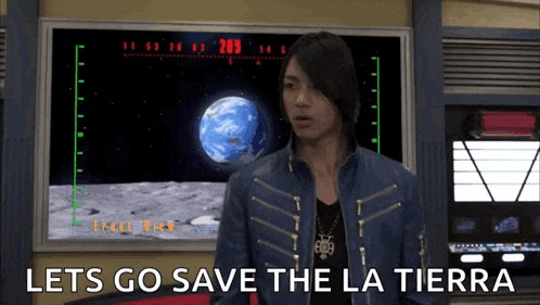 a man in a blue jacket is standing in front of a screen that says lets go save the la tierra