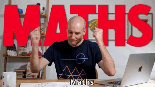 a man sitting in front of a laptop with the word maths in red letters