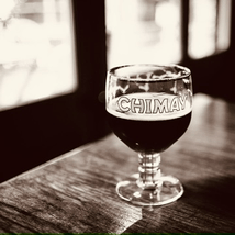 a glass of chimay sits on a table