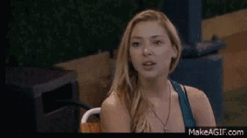 a woman is sitting in a chair with her mouth open and looking at the camera .