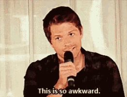a man holding a microphone says this is so awkward