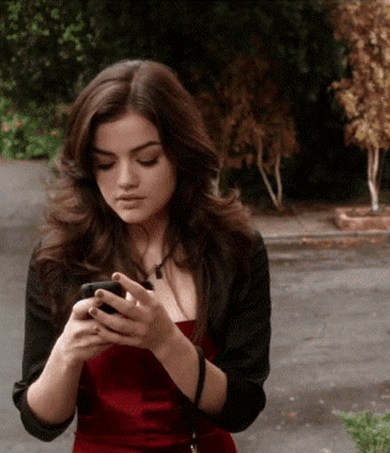 a woman in a red dress is using her cell phone