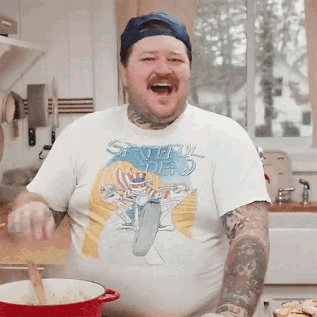 a man wearing a grateful dead t-shirt is cooking in a kitchen
