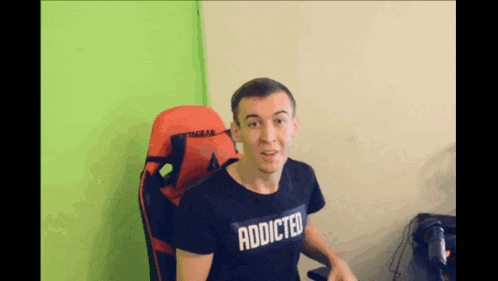 a man wearing a black shirt that says addicted