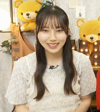 a woman is smiling in front of a teddy bear .