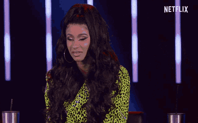 a woman in a leopard print shirt is sitting in front of a netflix logo