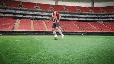 a soccer player wearing a red and white jersey with the word atletico on the front