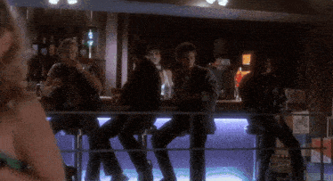 a blurred image of people sitting at a bar with a sign that says " no smoking " on it