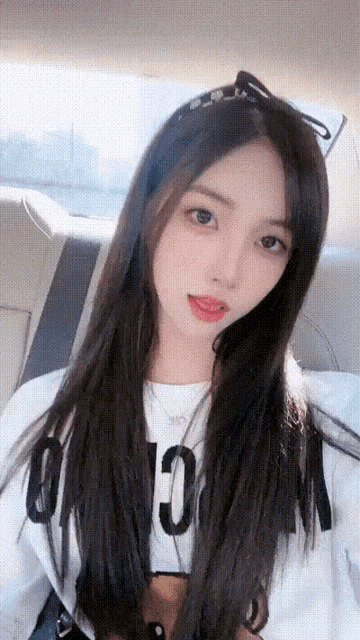 a woman wearing a white shirt with the number 10 on it looks at the camera