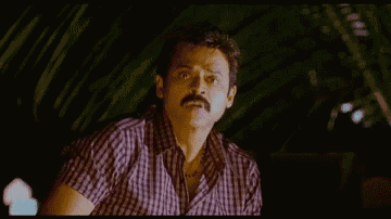 a man with a mustache is wearing a plaid shirt and looking at the camera .