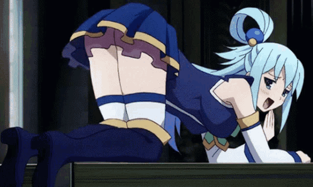 a girl in a blue skirt is laying on her stomach on a table .