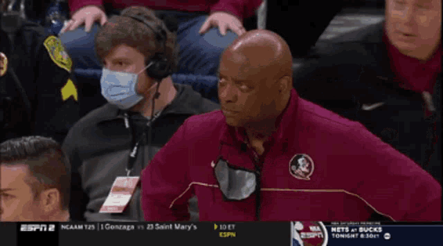 a man wearing a mask is watching a game on espn