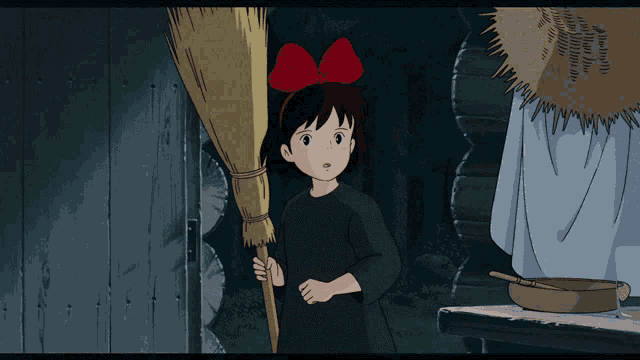 a little girl with a red bow on her head holds a broom