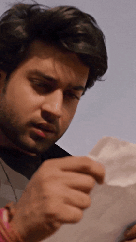 a man is holding a piece of paper in his hand