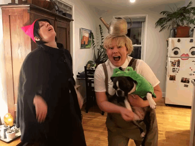a woman with a tea kettle on her head holds a small dog