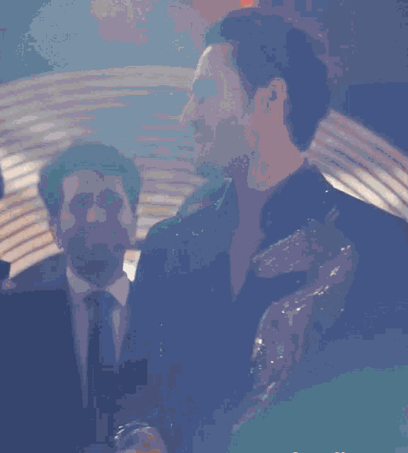 a man in a suit and tie is holding a trophy in his hand