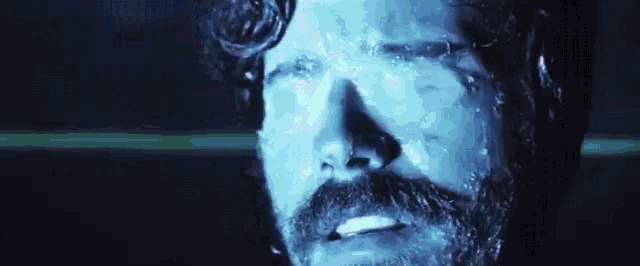 a close up of a man with a beard and mustache with water running down his face .