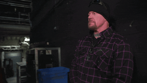 a man in a plaid shirt stands next to another man