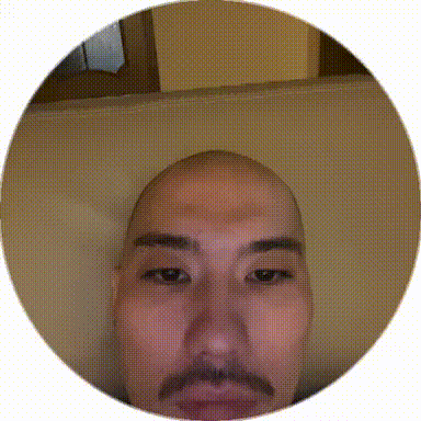 a man with a bald head and a mustache looks at the camera