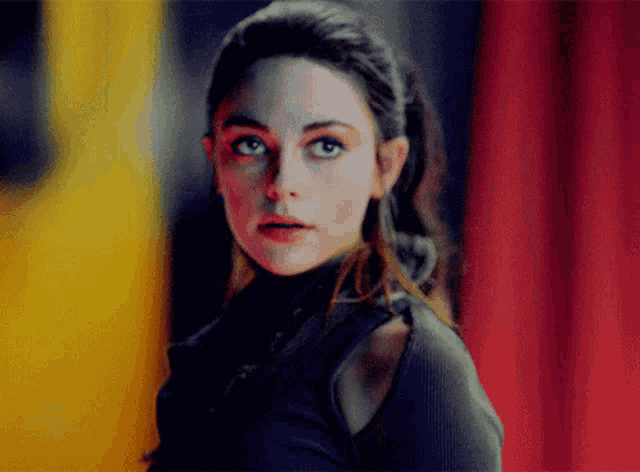 a close up of a woman 's face with a yellow and red background