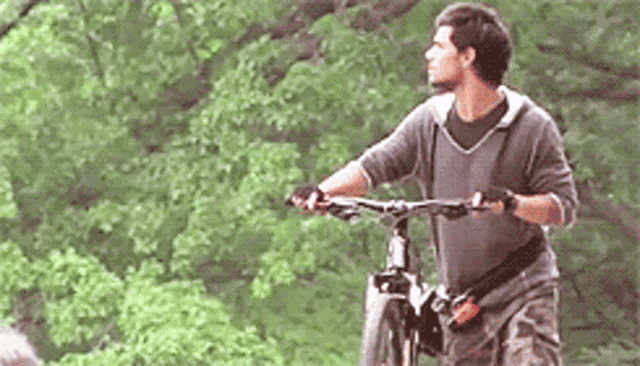 a man is riding a bicycle in a park .