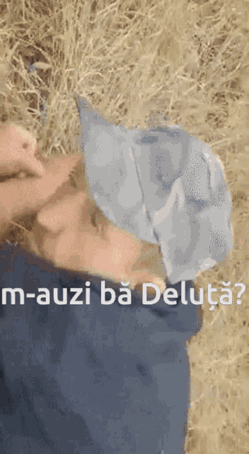a man wearing a hat is laying in the grass with the words " m-auzi ba deluta " written above him