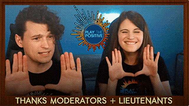 a man and a woman are making a heart with their hands in front of a play the positive sign