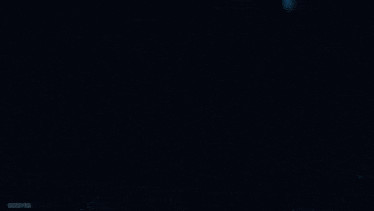 a close up of a purple and white glowing object in the dark .