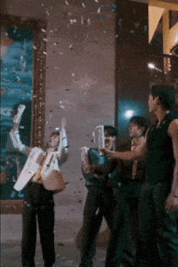 a group of people are standing in a room with confetti falling on them