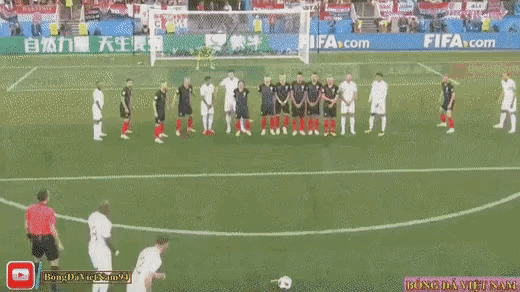 a soccer game is being played on a field with a banner for fifa.com in the background