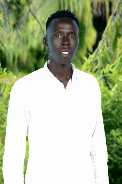 a young man in a white shirt stands in front of a lush green forest