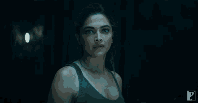 a woman in a tank top is looking at the camera with a question mark in the corner