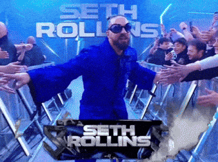 a man in a blue suit stands in front of a sign that says seth rollins on it