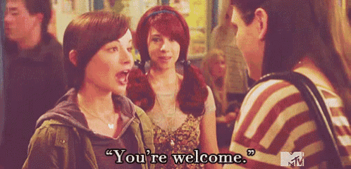 two women are standing next to each other and one of them is saying " you 're welcome " .