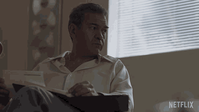 a man sitting in front of a window with a netflix logo