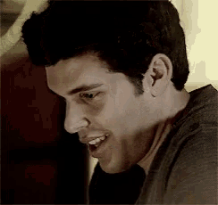 a close up of a man smiling with his mouth open