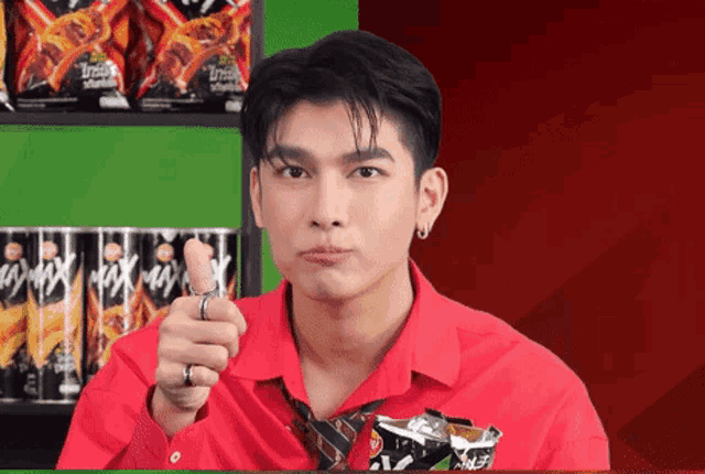 a man wearing a red shirt and tie is pointing at something