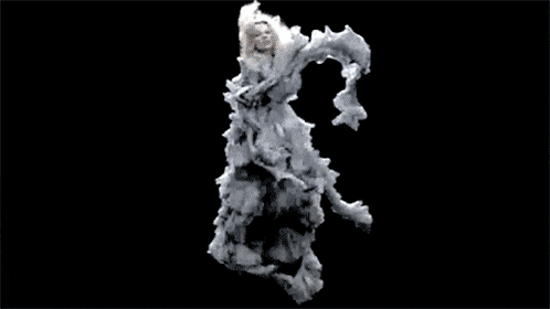 a woman in a white dress is dancing in a cloud of smoke .