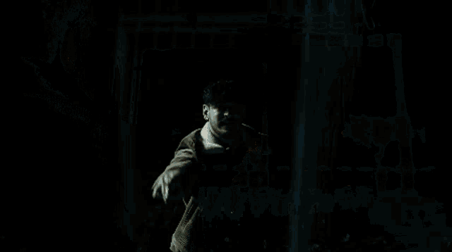 a man is looking out a window at night