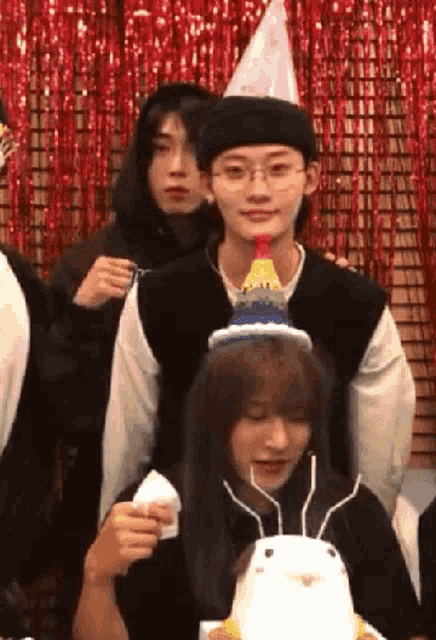 a group of people are celebrating a birthday with a cake .