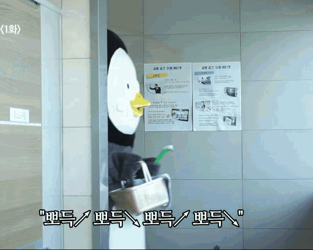 a penguin mascot is holding a toothbrush in front of a wall with posters in korean