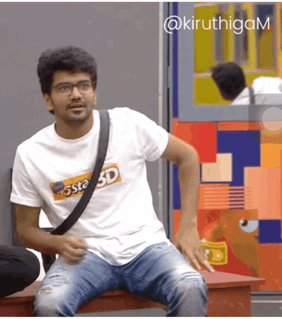 a man wearing glasses and a costa 3d t-shirt is sitting on a bench