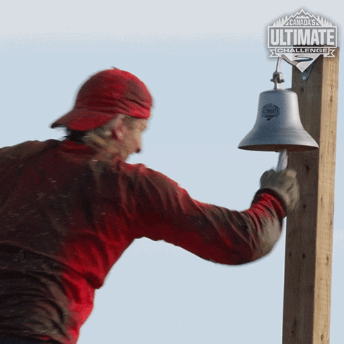 a man in a red shirt is ringing a bell with a canada ultimate challenge logo in the background