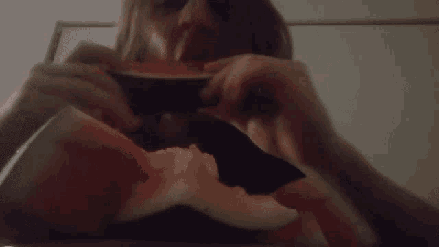 a woman eating a slice of watermelon with a knife
