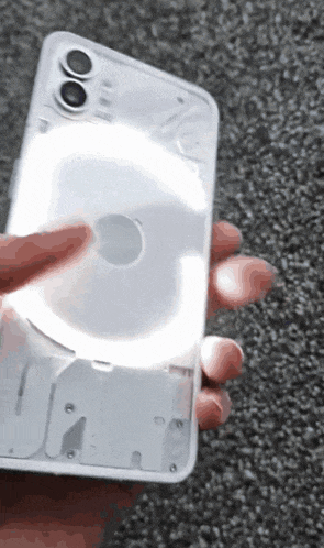 a person is holding a phone that has a light on it