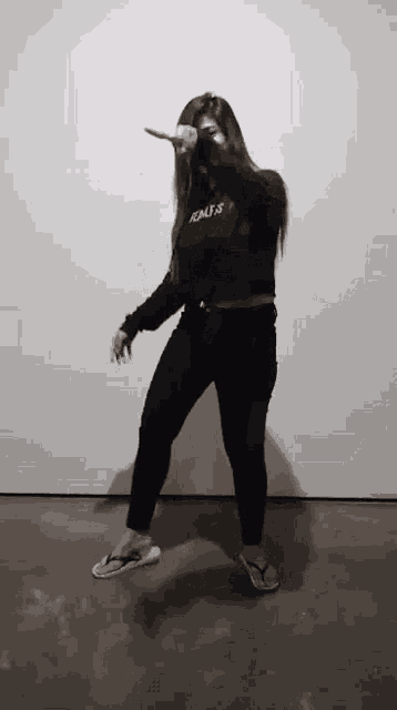 a woman wearing flip flops and a sweatshirt that says adults